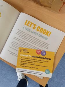 Cook book alongside the kindness postcards